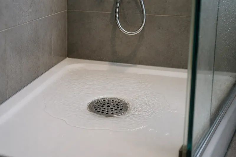 Stehendes Wasser in einer Dusche mit langsamem Ablauf
